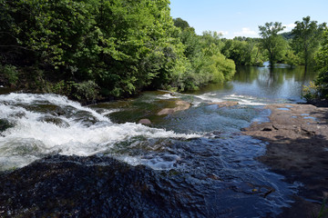 Fototapeta na wymiar A river flows down along rocks.
