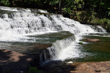 Multiple waterfalls flowing over different levels of rock.