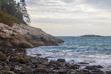 Obraz premium Dark blue water flows on the rocky shore of Sand Beach