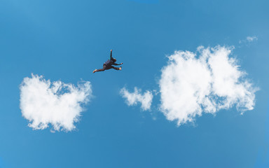 Silhouette a man jumping over white clouds and blue sky. Challenge, risk, freedom and imagination concept