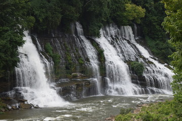 Fototapeta na wymiar Multiple waterfalls over layers of rock.