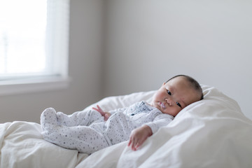 Little cute baby lying with milk bubble on his mouse