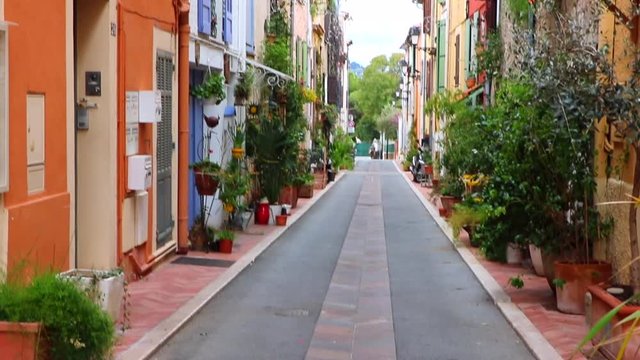 Old narrow street in Provence, French riviera, South France. Colorful Europe view, with plants, garden, tiny houses. Beautiful outdoor historic and culture view for urban tourism. Window, door, path. 