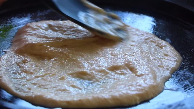 Homemade socca preparation, south France dish. Crimp on heat baking. Chickpea organic flour, healthy diet. Vegetarian lifestyle. Paste texture. Closeup on this traditional food. Cookie dough snack.