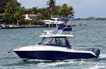 Blue and white sport fishing boat powered by three outboard engines