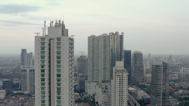 Aerial panorama view of skyline of Jakarta before sunset. dolly motion. reverse -reveal. Conceal