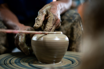 The old man's hands were molding clay pots.