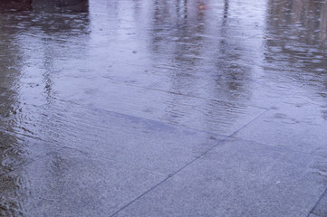 wet tiled sidewalk pavement at rainy day. background, texture.