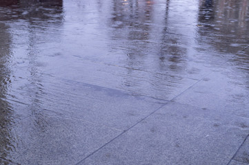 wet tiled sidewalk pavement at rainy day. background, texture.
