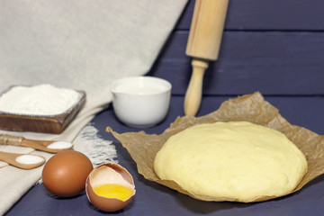 Yeast dough and ingredients for its preparation close-up, front view