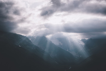 Panorama of misty mountains scene with dramatic sky in national park of Dombay