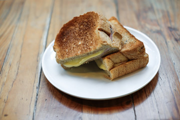 Sandwich with ham and cheese for breakfast in the morning on a white plate