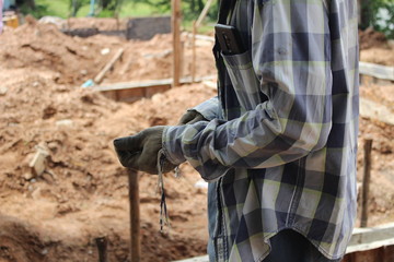 Construction workers are on the construction site and have phones in their pockets
