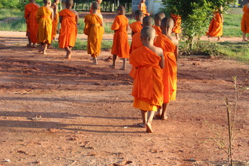 A novice is walking on a dirt road in the morning with warm sunshine