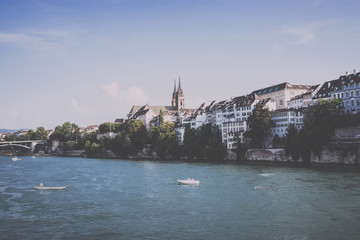 Fototapeta premium View on Basel city and river Rhine, Switzerland. People swim in water