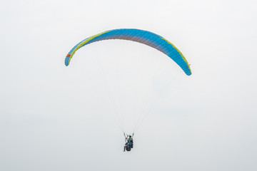 Blue paraglider flying in the sky