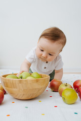 Fototapeta premium Baby boy playing with apples at home