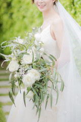 The beautiful bride in wedding dress smiled happily and Holding a bouquet of flowers