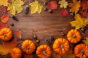 Autumn Thanksgiving background. Pumpkins, acorns and leaves on wooden table top view.
