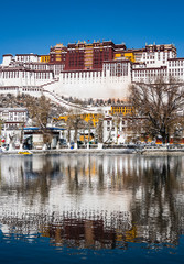Stunning view and reflection of the famous Potala Palace in the heart of Lhasa in Tibet province in China on a sunny winter day