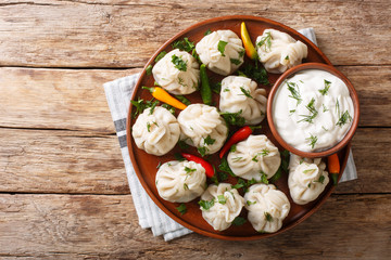 Tasty Georgian khinkali dumplings with sour cream close-up on a plate Horizontal top view