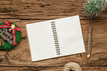 Top view of blank notebook on grunge wood  background with xmas decorations. Mockup Christmas background with notebook for wish list or to do list. Flat lay with copy space.