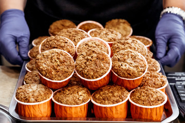 Pumpkin and carrot cupcakes. Healthy autumn pastries. Cafe concept. Baking in hands of pastry chef.