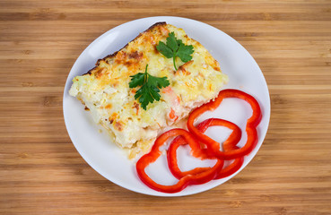 Cauliflower and seafood gratin portion on white dish, top view