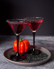 Two glasses with red cocktail for Halloween party on the dark background