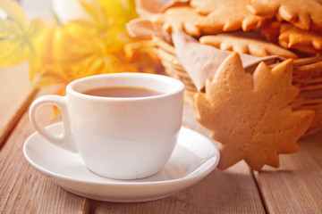 Cup of coffee, autumn leaves, cookies on the wooden table. Autumn harvest. Autumn concept.