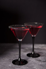 Two glasses with red cocktail for Halloween party on the dark background