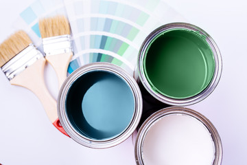 brushes and an open can with red on a plain gray background