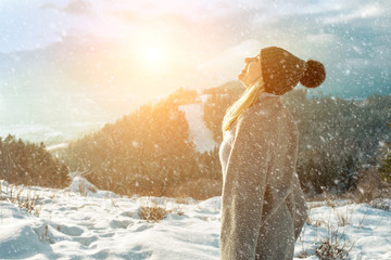 Portrait Happy woman traveler on the top of mountain and looking on beautiful winter snowy view.