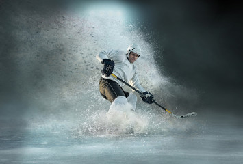 Caucassian ice hockey Players in dynamic action in a professional sport game play in hockey under stadium lights.