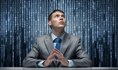 Man with folded hands looking upward