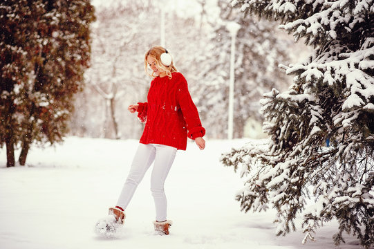 Cute Girl Walking In A Winter Park. Woman In A Red Sweater