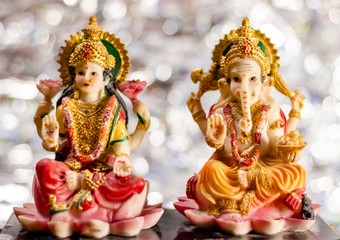 Diwali concept with Ganesha and Lakshmi statues with beautiful bokeh background