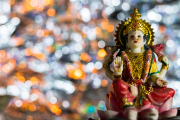 Low-angle shot of the statue of Lakshmi -the Goddess of wealth and prosperity on a Pink-lotus flower in Diwali Pooja