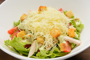 Chicken salad with cheese and crackers on the white dish. Closeup