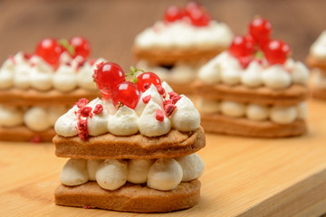 Cakes with berries on the board. Wood background