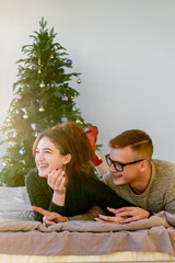 The guy with the girl celebrate the new year. Young couple celebrates christmas.