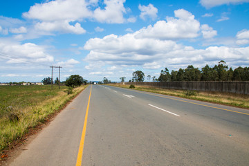 Tarred District Road Lined by Fence and Grass in Kwazulu-Natal