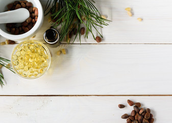 Cedar oil, branches and cedar cone on white. Copy space. Beauty and healthy concept.Energizing facial seed serums.