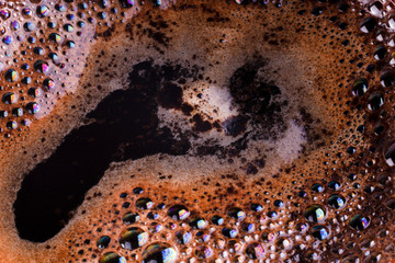 Close view of aromatic americano foam with colorful bubbles on the surface