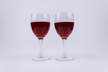 Two isolated glasses full of red wine on white background