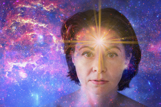 girl with soulful look against background of starry sky. on forehead of girl glowing star symbol of open mind. paranormal abilities, clairvoyance, mysticism. Elements of this image furnished by NASA