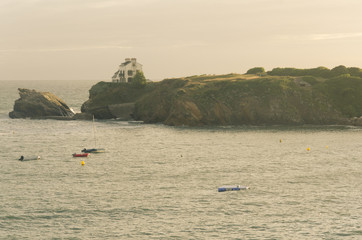 une maison sur les falaises de Bretagne avec l'océan et des bateaux