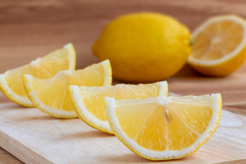 Fresh yellow lemon sliced placed on wooden table in the kitchen.