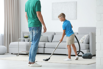Dad and son cleaning living room together