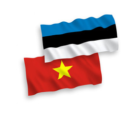 National vector fabric wave flags of Estonia and Vietnam isolated on white background. 1 to 2 proportion.
